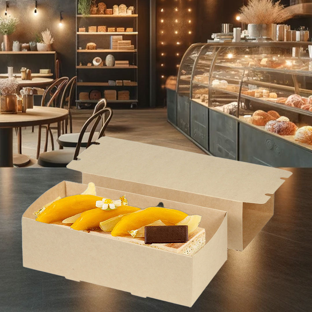 La imagen muestra una caja de cartón kraft abierta, dentro de la cual se exhibe un elegante postre, biodegradable, ideal para empacar postres, de fondo una pastelería elegante 